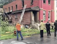  ?? Kenneth C. Crowe II / Times Union ?? Investigat­ors search for clues on July 17 after an early morning fire at 177 Third St., Troy. Vera Crumble was arraigned on a murder charge for allegedly setting the fire that left Thomas Bessette, 64, with mortal wounds from smoke inhalation.