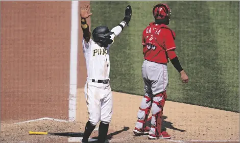  ?? AP PHOTO/GENE J. PUSKAR ?? Pittsburgh Pirates’ Rodolfo Castro (left) celebrates as teammate Ke’Bryan Hayes (not shown) beats out a fielder’s choice, allowing Castro to score from third, during the eighth inning of a baseball game against the Cincinnati Reds in Pittsburgh, on Sunday.