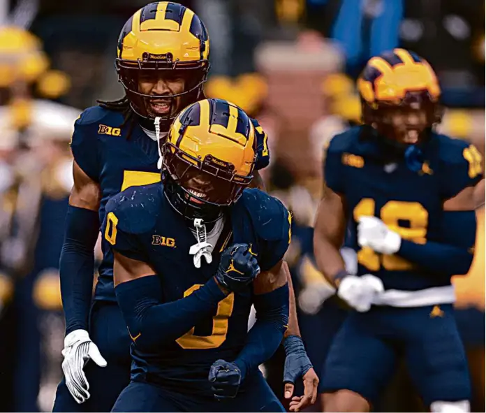  ?? GREGORY SHAMUS/GETTY IMAGES ?? Mike Sainristil and the Michigan defense were pumped after stopping Ohio State from reaching the Big Ten championsh­ip game once again.