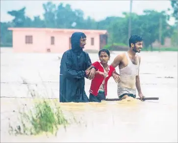  ?? AFP/Getty Images ?? N E PA L I S navigate an inundated area in Birgunj, Parsa district, south of Katmandu, the capital.