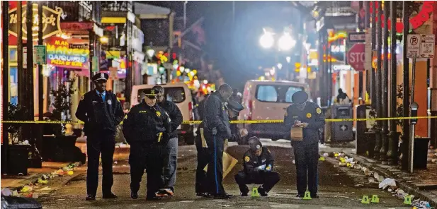  ??  ?? Polizisten inspiziere­n den Tatort einer Schießerei in der berühmten Bourbon Street in New Orleans.