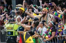  ?? (AP/The Times-Picayune/The New Orleans Advocate/David Grunfeld) ?? A reveler gets a coconut during the Zulu parade Tuesday on Canal Street in New Orleans.