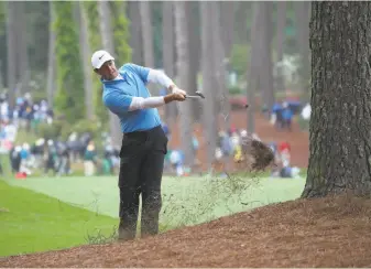  ?? David Cannon / Getty Images ?? Rory McIlroy plays his second shot out of the pine needles on the 17th hole Saturday. McIlroy, three shots behind Patrick Reed, can complete a career grand slam with a Masters title Sunday.