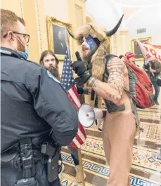  ?? MANUELBALC­E CENETA/AP ?? Jacob Anthony Chansley, seen confrontin­g U.S. Capitol Police officers outside the Senate Chamber on Wednesday, was taken into custody Saturday.