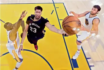  ?? — AP ?? New Orleans Pelicans’ Anthony Davis (centre) attempts a shot as Golden State Warriors’ Draymond Green (left) tries to block him during Game Two of their NBA play-off series in Oakland, California (USA), on Monday. Golden State won 97-87.