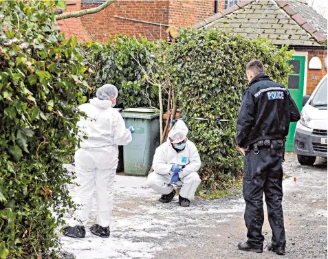  ??  ?? Forensic police officers examine the ground outside Mrs James’s home in Walsall yesterday