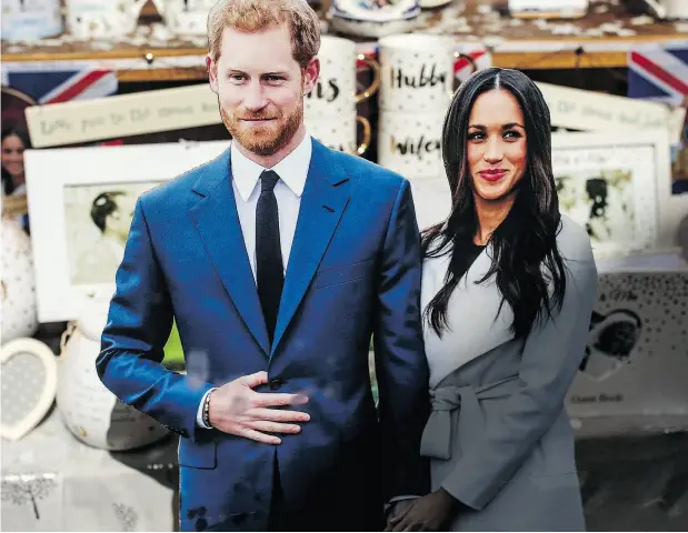  ?? JACK TAYLOR / GETTY IMAGES ?? Cardboard cut-outs of Prince Harry and his fiancée Meghan Markle sit among royal memorabili­a in a gift shop window.