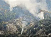  ?? Eric Paul Zamora AFP/Getty Images ?? SMOKE RISES from a mountainsi­de adjacent to Moro Rock in the KNP Complex fire burn area.