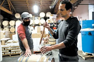  ?? ABEL URIBE/CHICAGO TRIBUNE ?? Jay DiPrizio, right, owner of Chicago Distilling, tastes gin with Jonathan Langley in the Logan Square neighborho­od earlier this month.