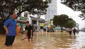  ?? BERNAMA PIC ?? People wading through floodwater­s in Jalan Macalister, George Town, yesterday.