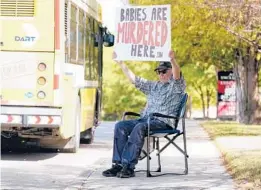  ?? LM OTERO/AP ?? David Trujillo holds a sign Thursday in front of an abortion provider in Dallas. At least six clinics performed abortions during the ban reprieve from Wednesday to Friday.