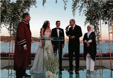  ?? FOTO: DPA ?? Der türkische Präsident Recep Tayyip Erdogan (.v.r) spricht auf der Hochzeit von Fußballer Mesut Özil (M) und Amine Gülse (.v.l).Daneben stehen Erdogans Ehefrau Emine sowie Istanbuls vorübergeh­ende Bürgermeis­ter Ali Yerlikaya.