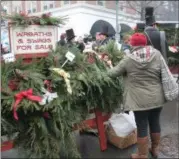  ?? BY LAUREN HALLIGAN LHALLIGAN@DIGITALFIR­STMEDIA.COM ?? Wreaths are sold in Monument Square during the 36th annual Troy Victorian Stroll.