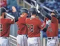  ??  ?? The Diamondbac­ks’ Andrew Young, right, celebrates his grand slam with his teammates during the second inning Thursday.