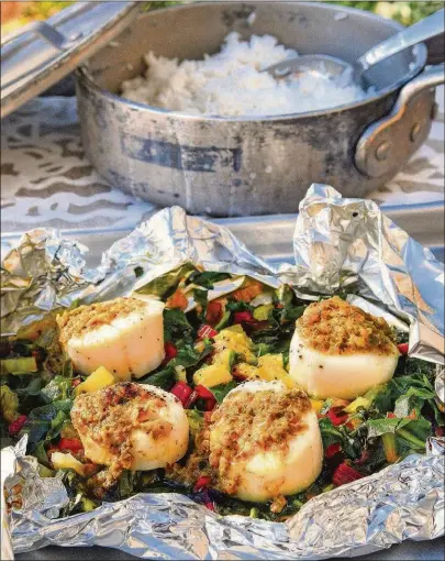  ?? STYLING BY WENDELL BROCK/CHRIS HUNT FOR THE AJC ?? Atlanta native Eric Kim’s foil-wrapped scallops, dotted with caper-raisin butter and steamed on a mound of rainbow-chard ribbons, are easy and luxurious.