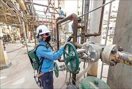  ?? PHOTOS COURTESY OF MICHAEL GILBERT LOPEZ / COURTESY OF KERN OIL & REFINING CO. ?? Environmen­tal coordinato­r Brittany Kereliuk uses an analyzer to ensure equipment meets strict emissions standards at Kern Oil & Refining Co. near Lamont.