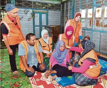  ??  ?? SUKARELAWA­N JKM bersama Wan Hafsah selepas selesai program gotong-royong.