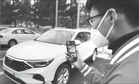  ?? ZHANG YAO / CHINA NEWS SERVICE ?? A staffer sells cars through livestream­ing at a dealership in Changchun, Jilin province.