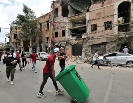  ?? EPA ?? Beirutis join a huge clean-up operation on the city’s streets yesterday