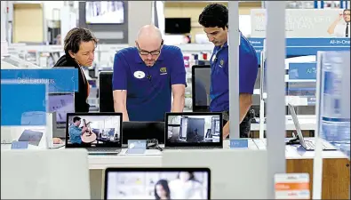  ?? AP/GERRY BROOME ?? Employees assist a customer with a computer at a Best Buy store in Cary, N.C., in this May photo. Consumer spending rose just 0.1 percent in May after climbing 0.4 percent in both March and April.