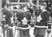  ?? FRANK GUNN THE CANADIAN PRESS ?? Mitch Marner celebrates a goal with Morgan Rielly and Ron Hainsey. The three are among the Maple Leafs who have played at least 70 games this season.