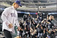  ?? AP PHOTO ?? In this January 2012 file photo, new Texas Rangers pitcher Yu Darvish walks onto the field as members of the media line up to take pictures after a news conference at Rangers Ballpark in Arlington, Texas.