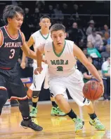  ?? JIM THOMPSON/ JOURNAL ?? Mora’s Travis Romero, right, drives against Menaul’s Kyrie Hu during Wednesday night’s Class 2A quarterfin­al. Romero scored 16 points as the Rangers won 66-58.