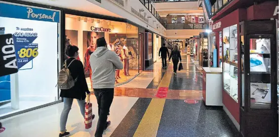  ??  ?? En modo “galería”. La gente hace compras en un shopping center en la ciudad de Córdoba. Abrieron el viernes, pero sin patios de comida ni cines.