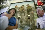  ?? JOHN MINCHILLO — THE ASSOCIATED PRESS FILE ?? Pat Murray, left, and Ken Kreuter sit beneath a portrait of their son Marine Sgt. David Kreuter, top right, at the traveling Eyes of Freedom Lima Company Memorial then displayed at the Cincinnati Masonic Center in 2015. Kreuter was one of 14 Marines from Ohio-based Lima Company who were killed by an IED explosion in Iraq 15 years ago. Some survivors and families of those killed had planned a 15-year reunion this weekend, but it had to be canceled amid restrictio­ns for the COVID-19 pandemic.