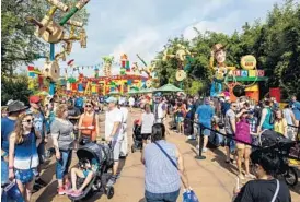  ??  ?? Visitors queue up for the Slinky Dog Dash roller coaster ride Saturday at Disney’s Hollywood Studios on the opening day of Toy Story Land.