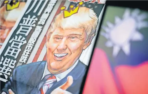  ?? FOTO: DPA ?? Taiwanisch­e Zeitungen feierten den designiert­en US-Präsidente­n Donald Trump für ein Telefonat mit der taiwanisch­en Präsidenti­n. China wertete das Telefonat als Bruch der über Jahre geltenden Ein-China-Politik. Rechts ist die Flagge Taiwans zu sehen.