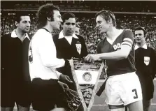  ?? HEINRICH SANDEN / DPA ?? Wimpeltaus­ch der Kapitäne bei der WM 1974: Franz Beckenbaue­r (links) und Bernd Bransch (rechts).