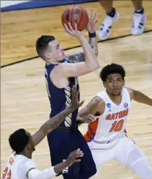  ?? Associated Press ?? Guard Carlos Jurgens, center, and Oral Roberts continued their run of upsets, knocking off Florida on Sunday.