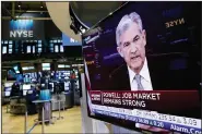  ?? AP/RICHARD DREW ?? Federal Reserve Chairman Jerome Powell’s news conference in Washington appears on a television Wednesday on the floor of the New York Stock Exchange after the Fed raised its benchmark interest rate to reflect a solid U.S. economy.