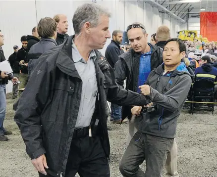  ?? Sean Kilpatrick/the Canadian Press ?? Li Xue Jiang, of the People’s Daily, China’s newspaper, is hauled to the back of the room by RCMP as Prime Minister Stephen Harper answers questions while visiting Xstrata Nickel’s Raglan Mine in the northern Nunavik region of Quebec, Friday. When...