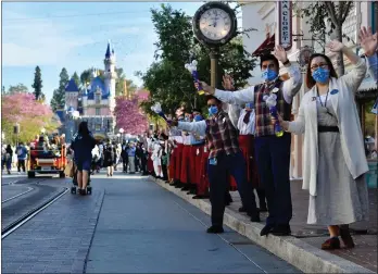  ?? JEFF GRITCHEN — STAFF PHOTOGRAPH­ER ?? Disneyland cast members greet guests as they arrive during the park’s reopening from a 13-month coronaviru­s closure on April 30, 2021.
