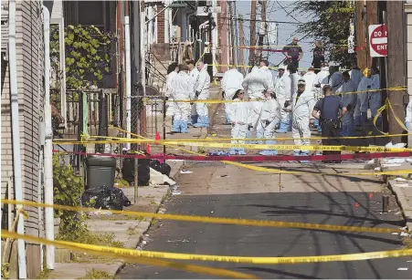  ??  ?? GRIM: Investigat­ors surround the scene of a fatal car explosion in Allentown, Pa., Saturday night. Three males died in what authoritie­s call a ‘criminal incident.’