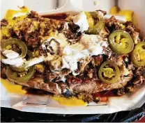  ?? Photos by Chuck Blount / Staff ?? Brooks BBQ: Chopped brisket, cheese, jalapeños and a hearty sour cream-barbecue sauce mix top the smoky creation.