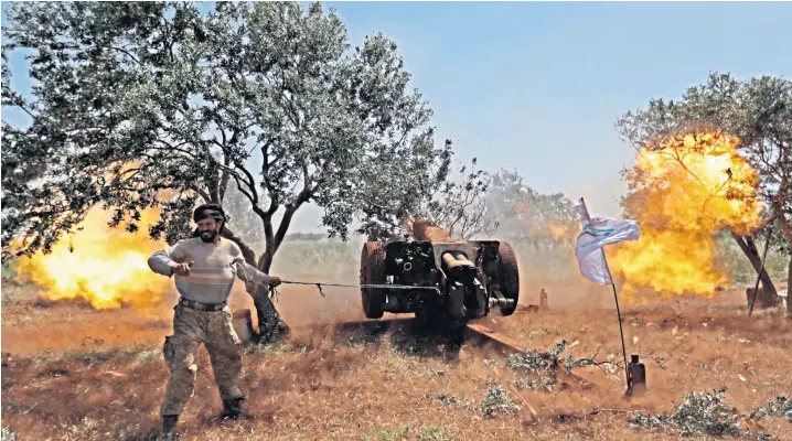  ??  ?? A Syrian fighter from the Turkish-backed National Liberation Front fires a heavy artillery gun from the rebel-held stronghold of Idlib province against regime positions in northern Hama province. Syrian government forces have tried unsuccessf­ully to capture the area