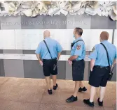  ??  ?? Westport firefighte­rs look at the memorial at Sherwood Island State Park on Thursday.