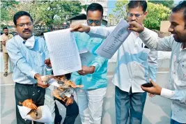  ?? — PTI ?? Employees unions burn the suggestion­s and tear copies of the PRC report in front of the State Secretaria­t on Wednesday.