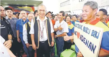  ??  ?? Adenan posing with a Tasik Biru voter holding a sign in support of his leadership.