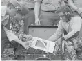  ??  ?? Indonesian military personnel examine the flight-data recorder of AirAsia Flight 8501 on Monday.