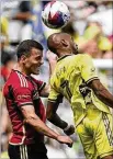  ?? GEORGE WALKER IV/AP ?? Nashville’s Fafà Picault (right) heads the ball past Atlanta United defender Brooks Lennon during an April 29 match in Nashville, Tenn.