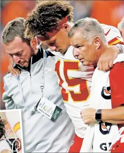  ?? Getty Images (2) ?? QB-SNEAK ATTACK: After lying on the field (inset) following an injury suffered during a quarterbac­k sneak, Chiefs quarterbac­k Patrick Mahomes left Kansas City’s 30-6 win at Denver with what NFL Network reported is a dislocated kneecap.