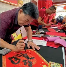  ?? — Bernama photo ?? Calligraph­er Weoh Eng Chew, 66, was among those brought to Gua Musang from Kota Bharu to draw auspicious words and good wishes for the Dragon Year.