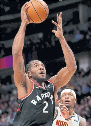  ?? MATTHEW STOCKMAN GETTY IMAGES ?? Raptors forward Kawhi Leonard drives to the net against the Nuggets in Denver on Sunday night.