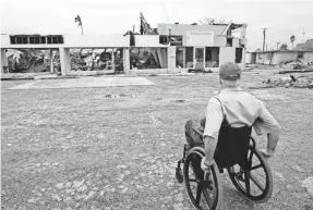  ??  ?? Gov. Greg Abbott looks over damaged stores in Rockport, Texas, during a tour Aug. 28, two days after Hurricane Harvey hit the town. COURTNEY SACCO/CORPUS CHRISTI CALLER-TIMES VIA USA TODAY NETWORK