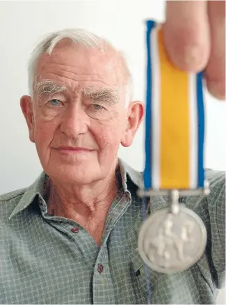 ?? Photo: KRIS DANDO/FAIRFAX NZ ?? Taonga back home: Angus Langbein with one of his father’s World War I medals.