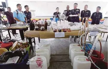  ?? PIC BY MIKAIL ONG ?? State police chief Datuk Chuah Ghee
Lye (third from right) showing the seized drugs and other items at the state police contingent headquarte­rs in George Town yesterday.